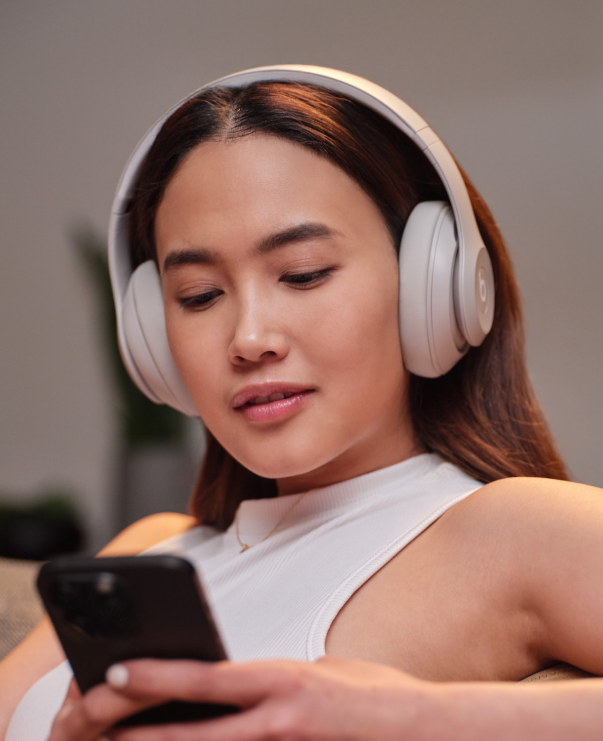 佩戴柔沙色 Beats Studio Pro 无线头戴式耳机的人在打电话